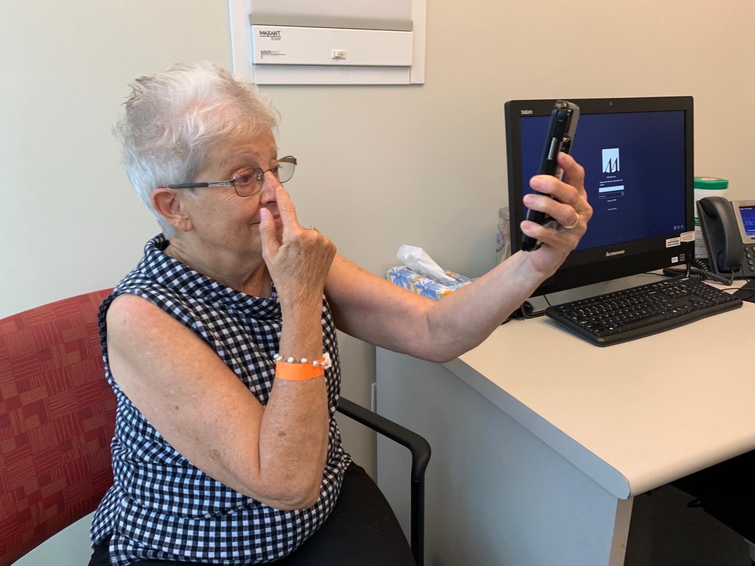 A female patient participates in a video screening test on a smartphone