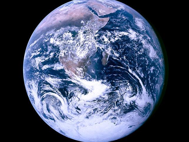Earth as seen from space with blue oceans, white clouds and brownish land