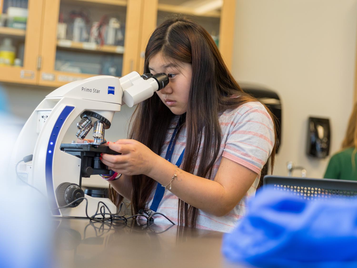 Girl looking through microscope 