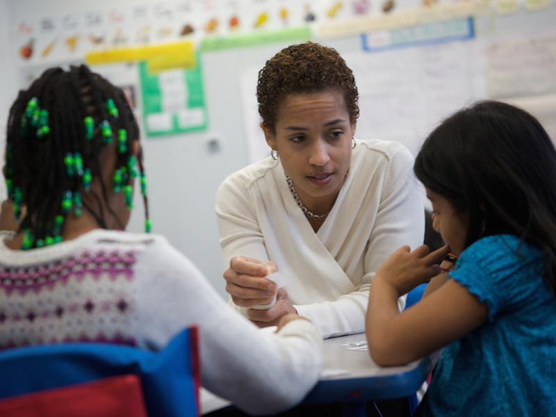A teacher speaking with two students