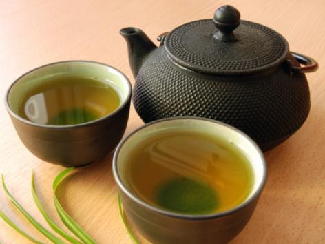 black teapot with two cups of green tea