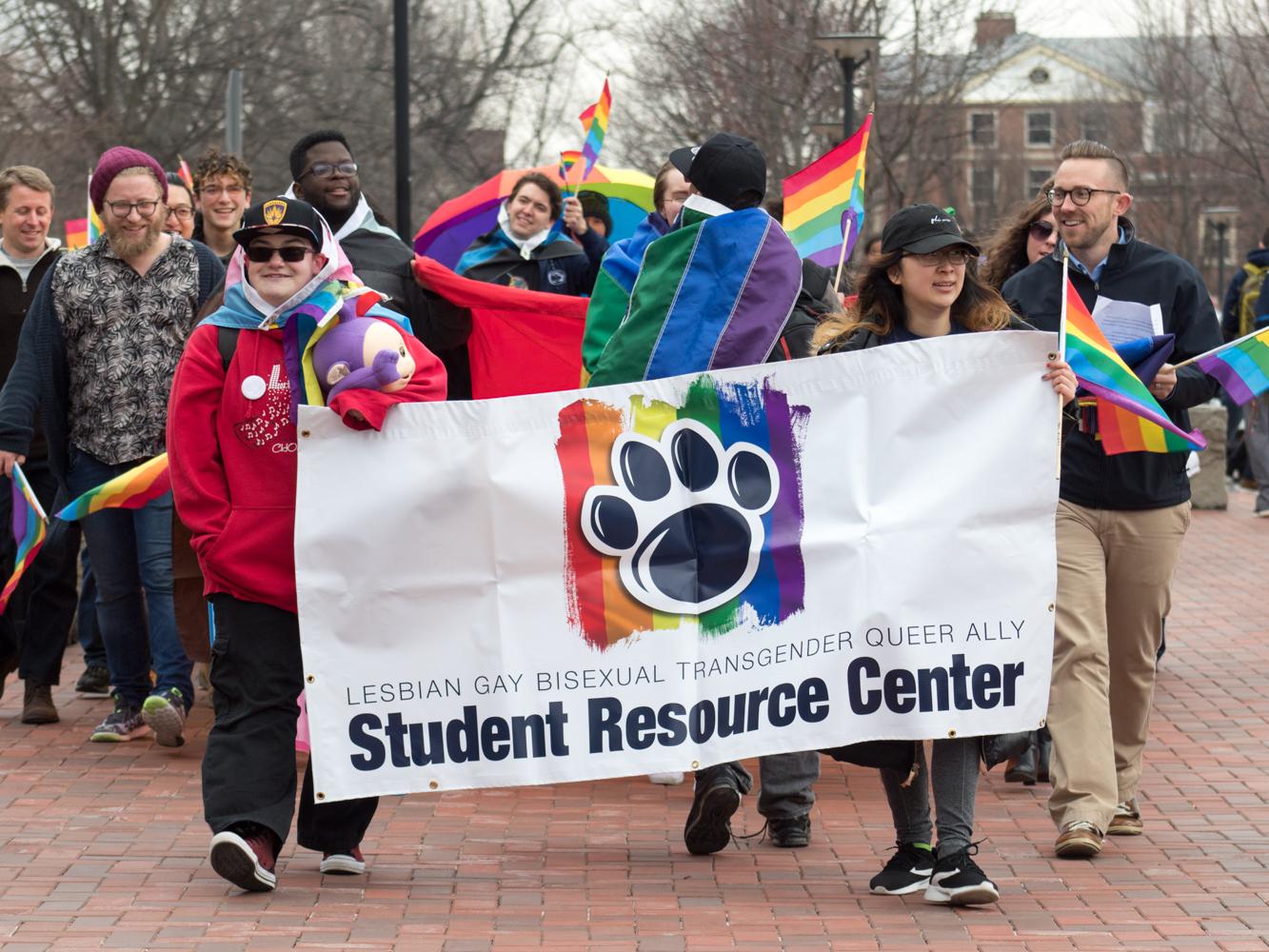 People march with LGBTQA banner down Pollock Road
