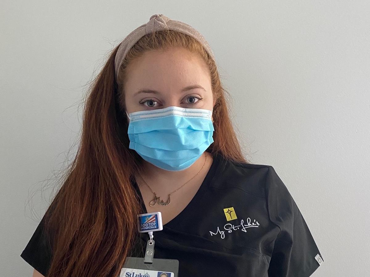 young woman in scrubs and face mask