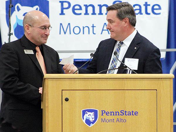Randall Ackerman accepts check from Jim Ingram.