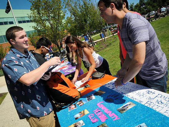 Students gather at a table during an activities fair.