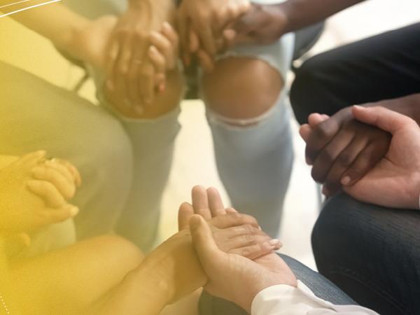 Photo of people holding hands with a yellow gradient 