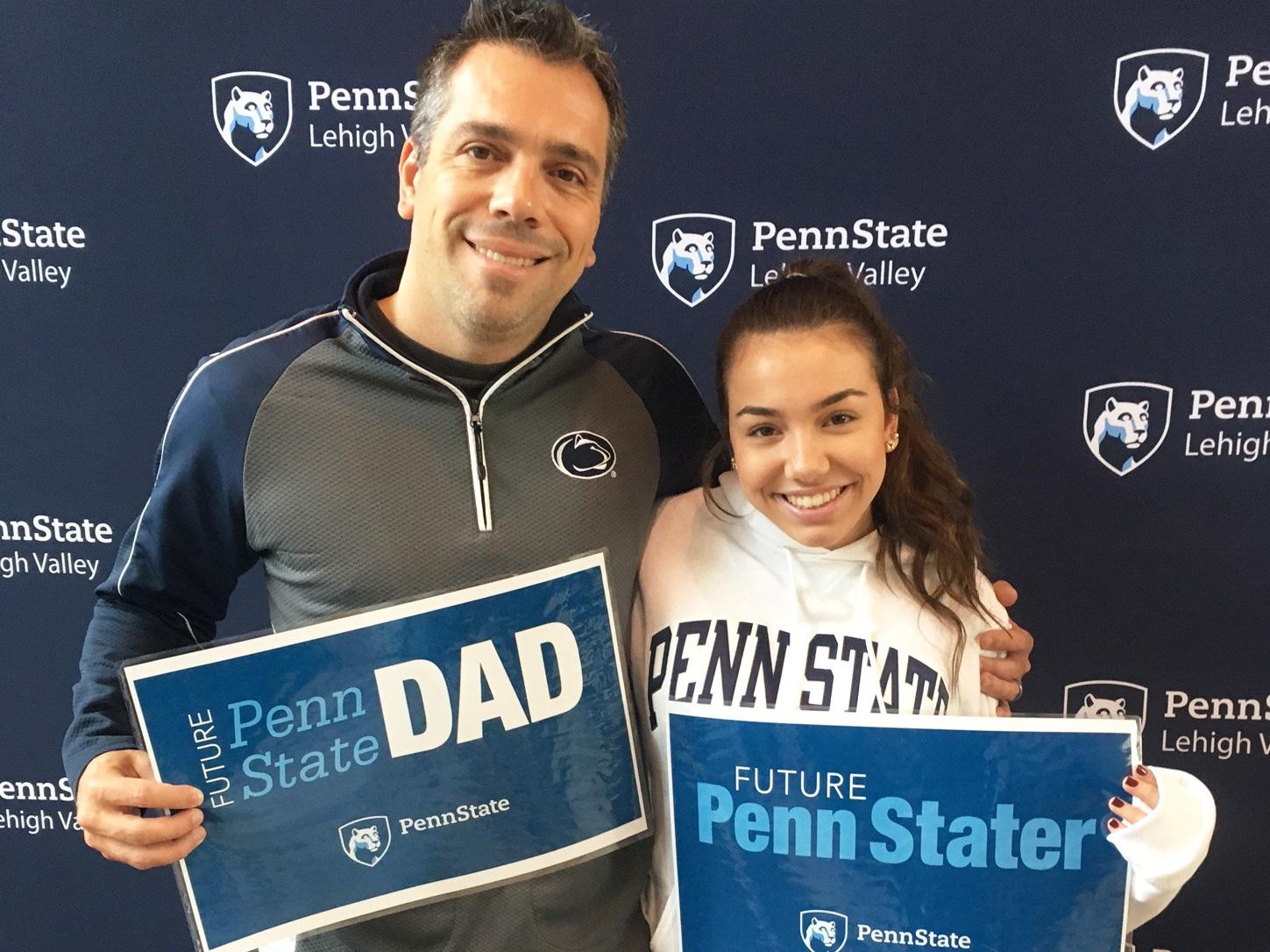 a Dad and daughter pose with Penn State Lehigh Valley signs