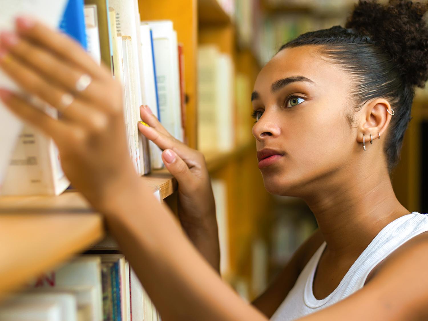 female looking at books on shelf