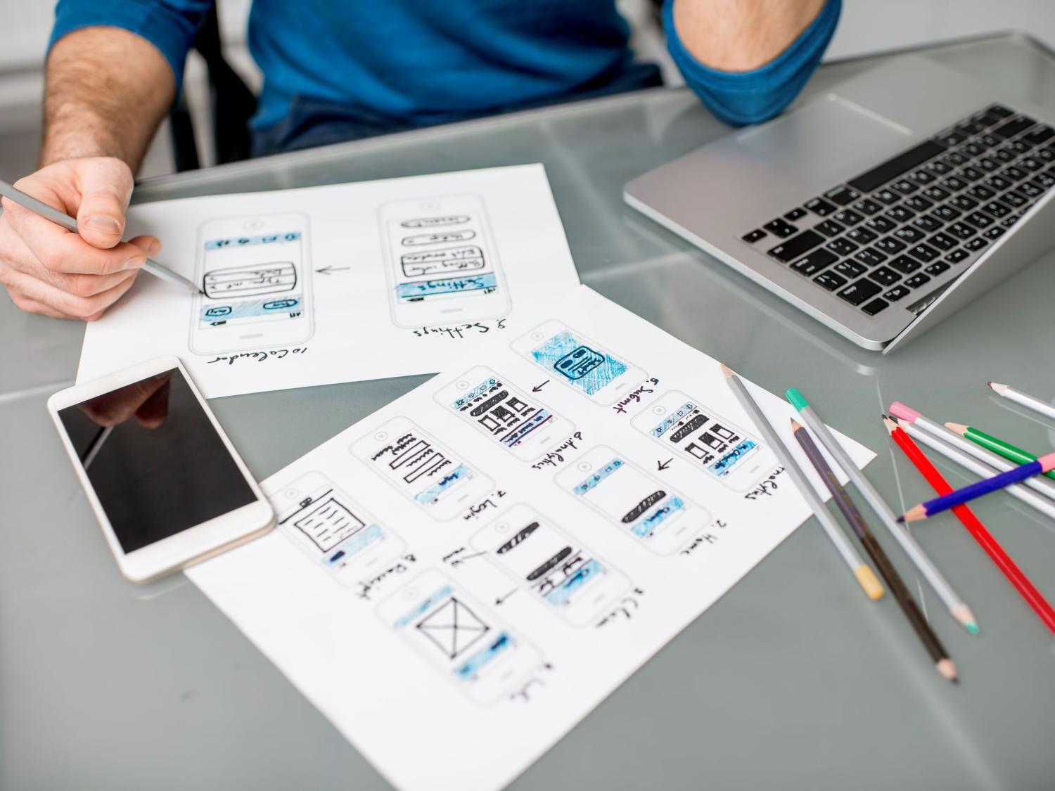 Wireframing technology designs on paper with colored pencils