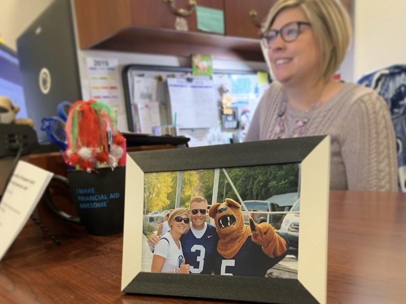 Framed photo of male and female smiling on desk with woman working in background