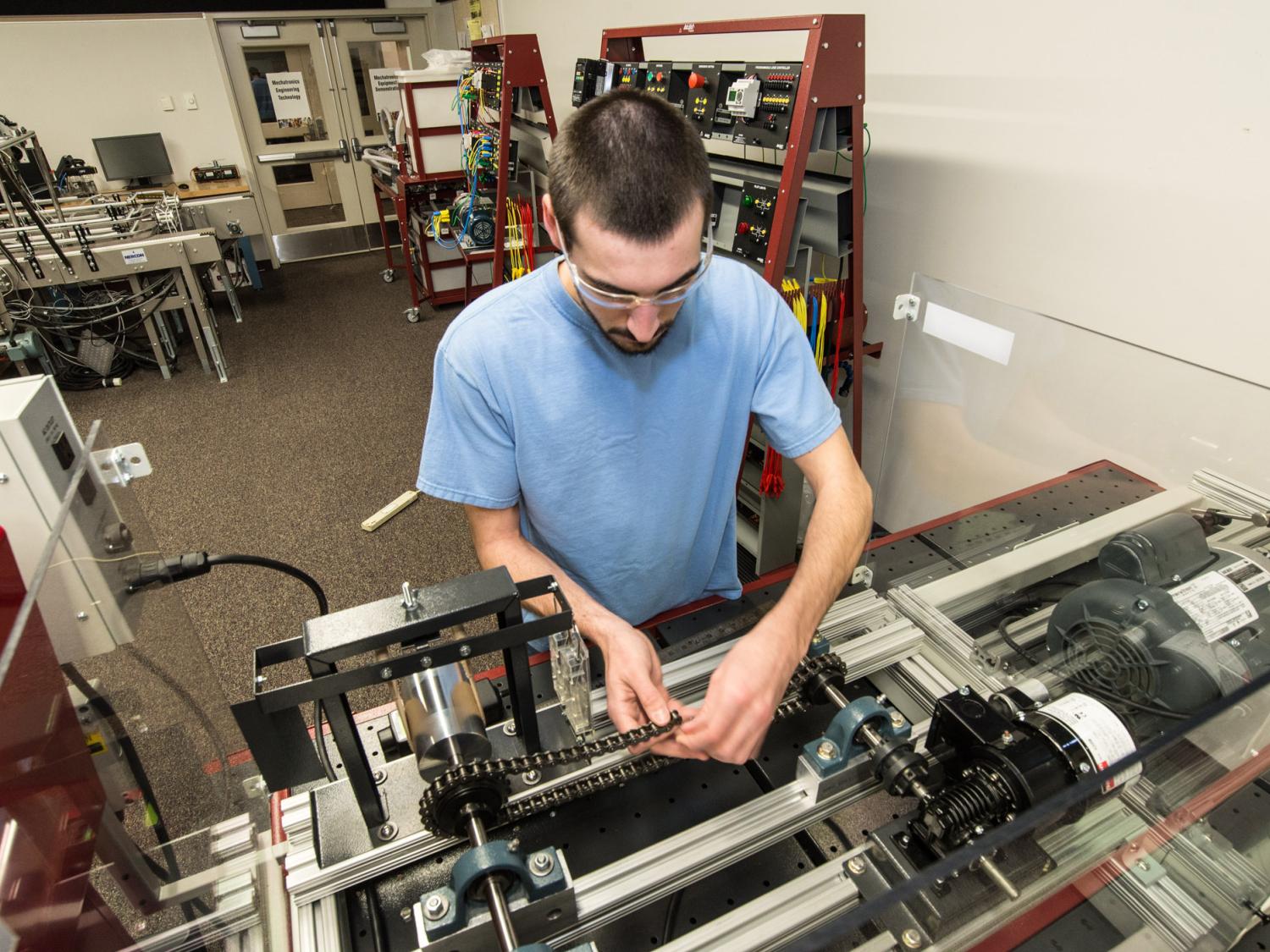 A student works on an engine in a workshop.
