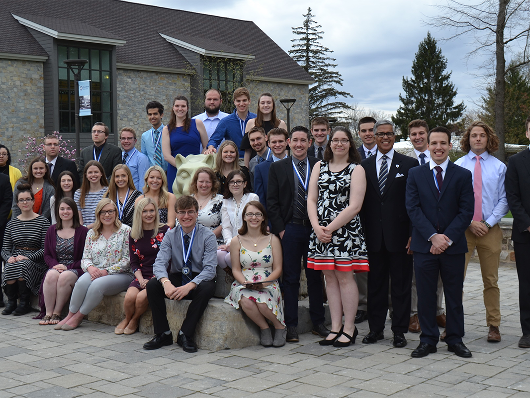Academic award winners as a group posing in front of the lion shrine on campus