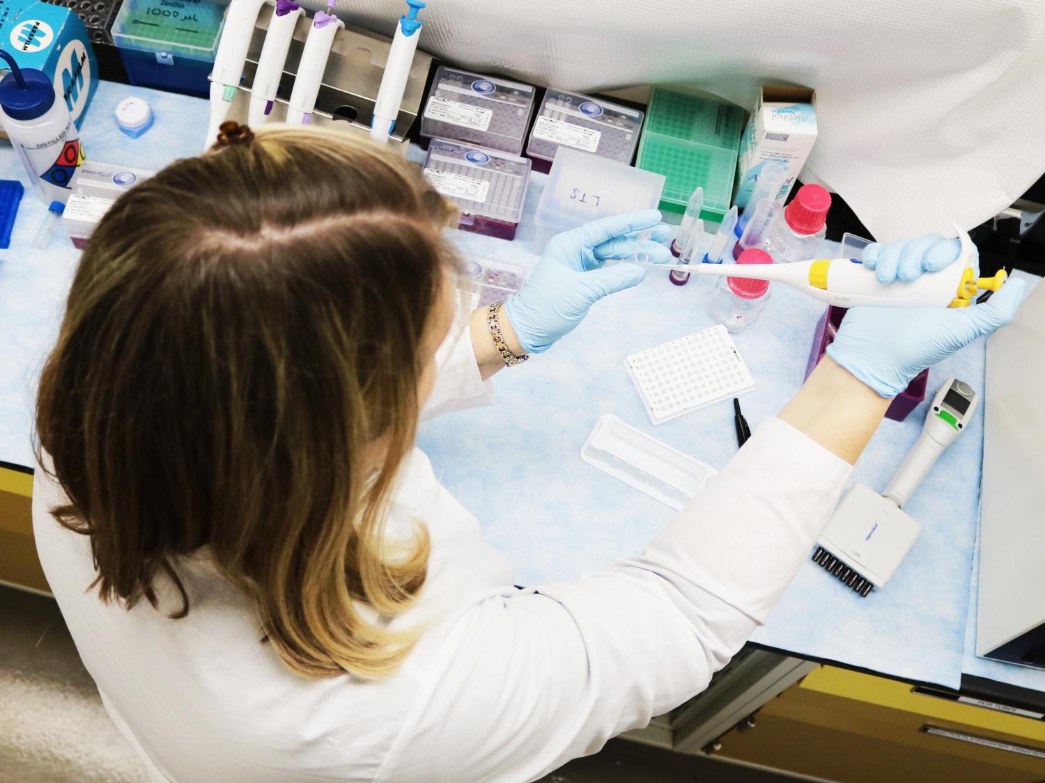 Scientist with pipett preparing a sample viewed from above
