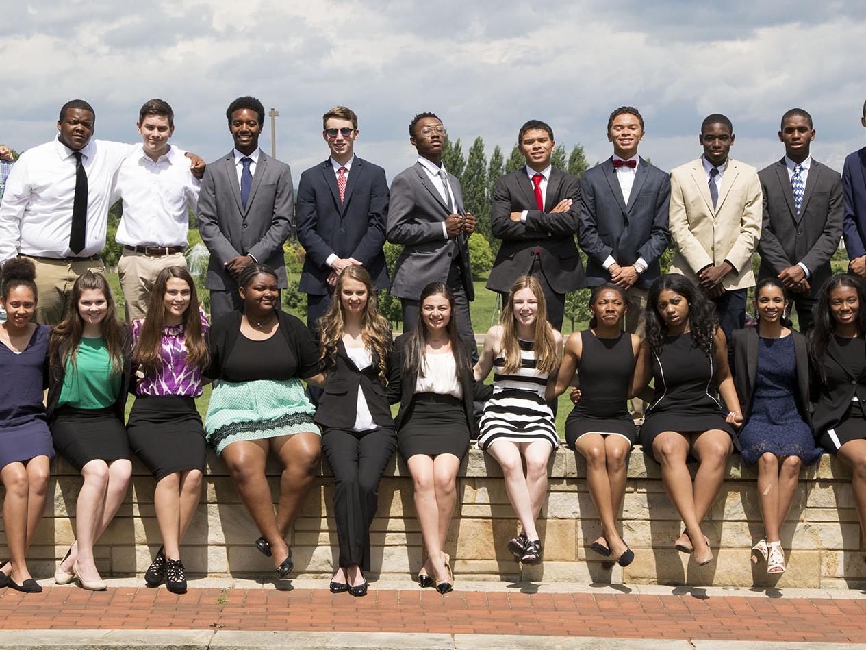 2017 BOSS class poses on wall outside of the Business Building.
