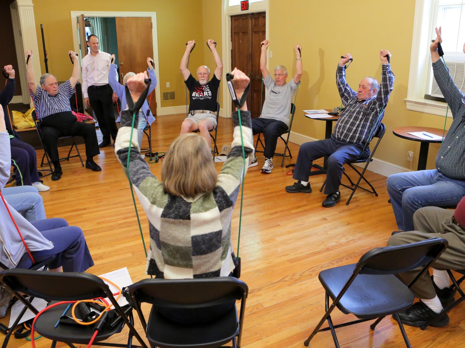 A group of people sits in a circle in a strength-training class.