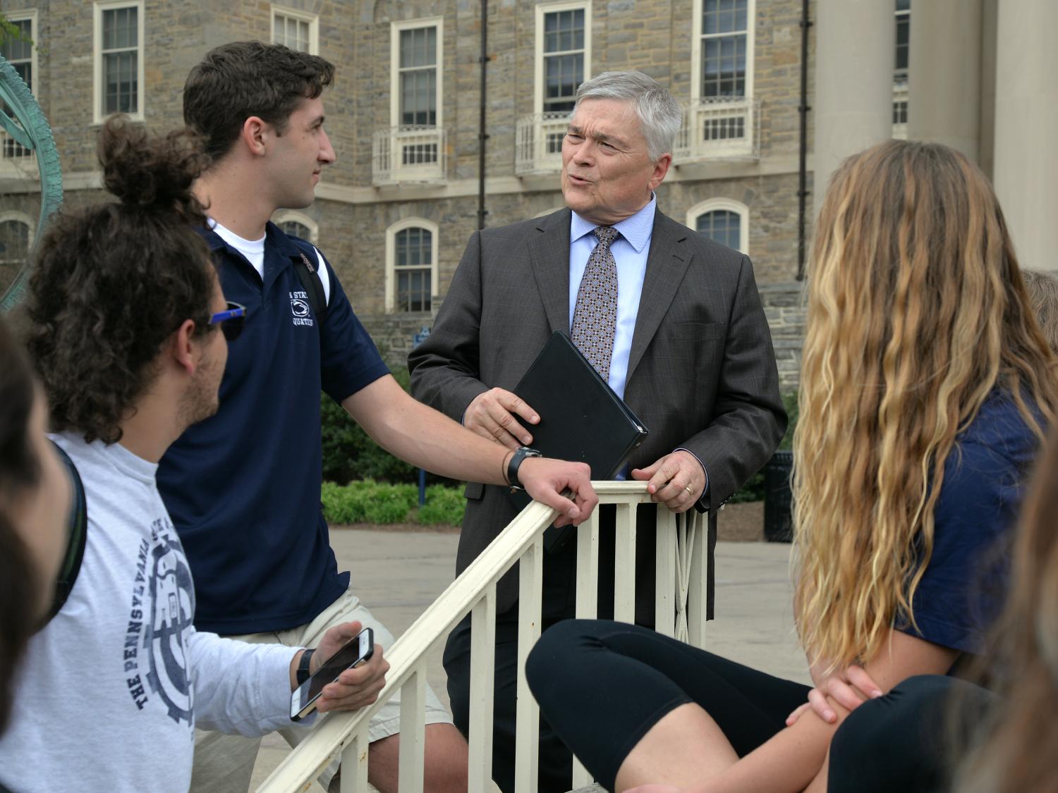 Penn State President Eric Barron chats with a group of students in front of Old Main on April 22, 2016.