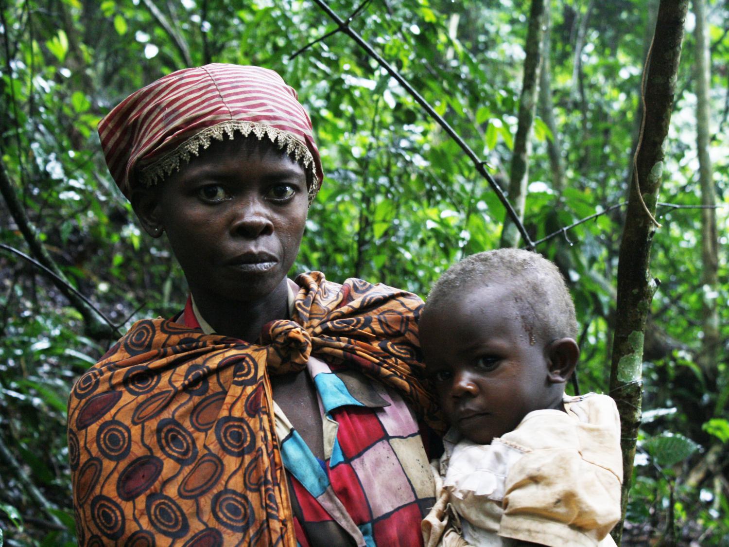 Batwa young woman holding child