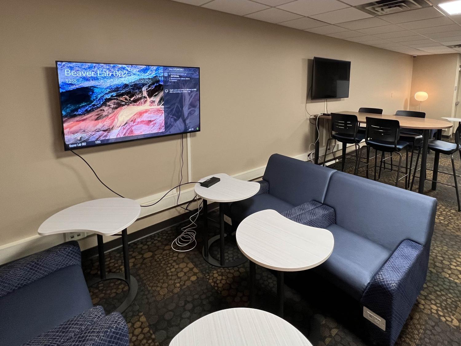 lounge-style chars, tables, and digital monitors set up in the newly redesigned Beaver Hall computer lab