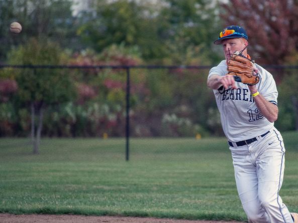 A Penn State Behrend baseball player fields the ball.