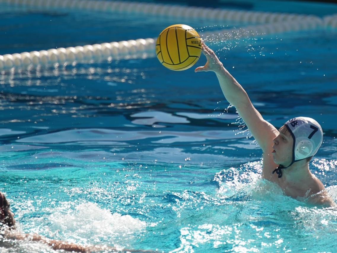 A Penn State Behrend water polo player throws the ball.