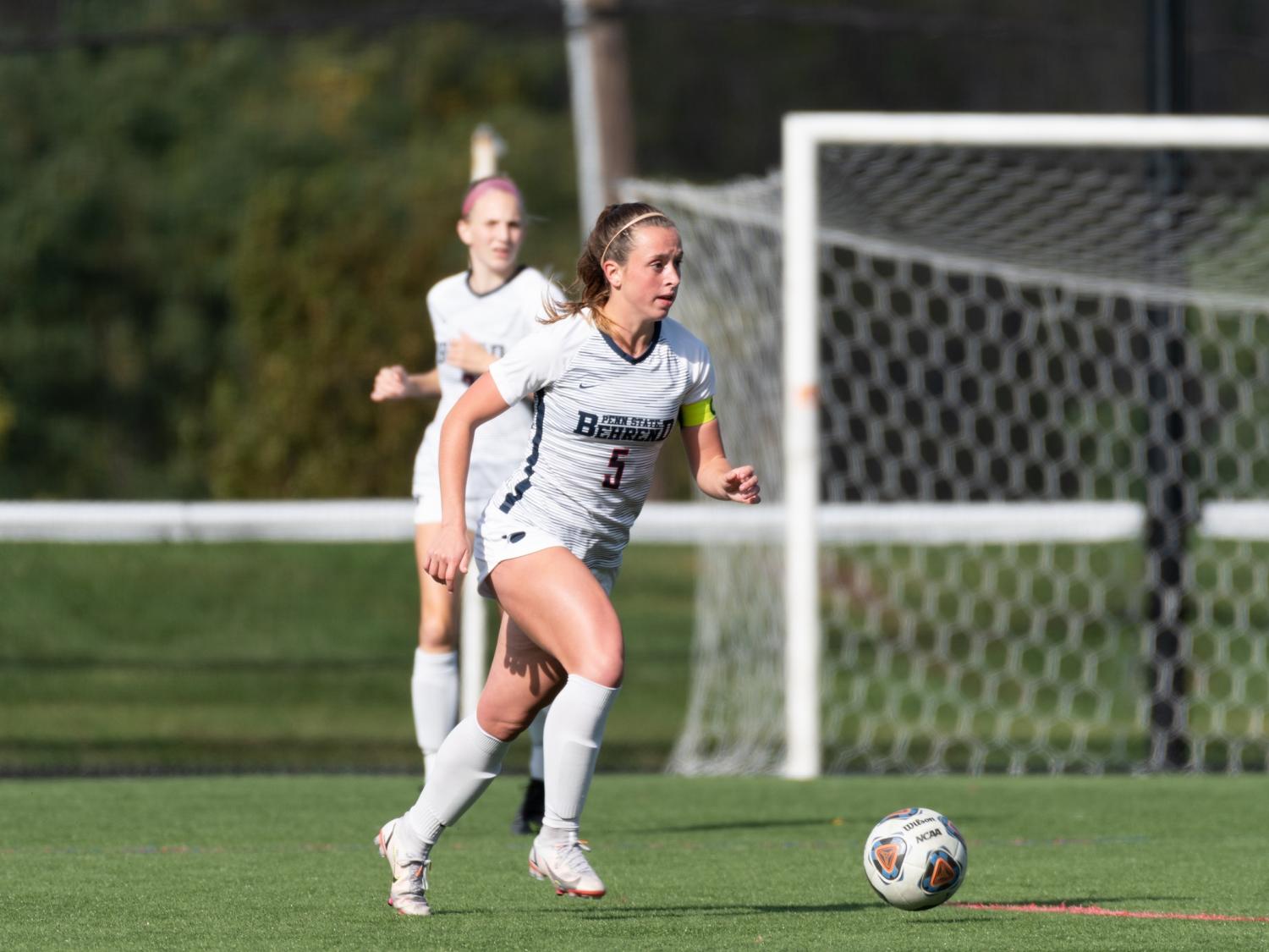 A Penn State Behrend soccer player prepares to kick the ball.
