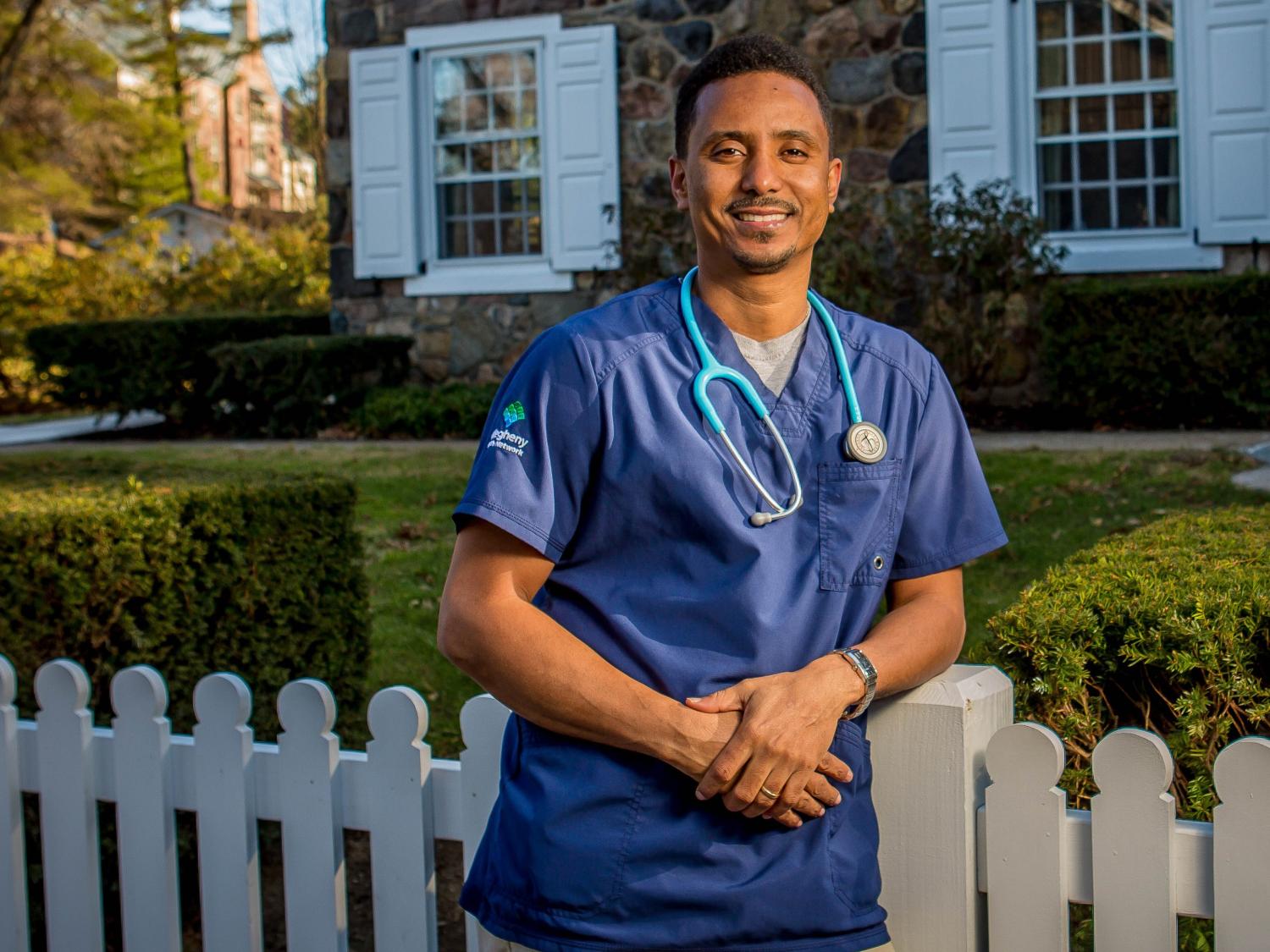 Penn State Behrend graduate Abraham Berhane stands in front of Glenhill Farmhouse.