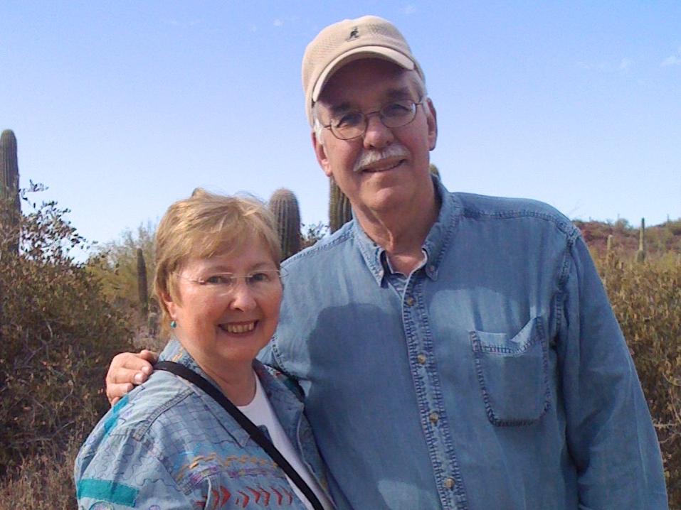 Patricia Best and Thomas Ray pose and smile for a pic while traveling in a desert.