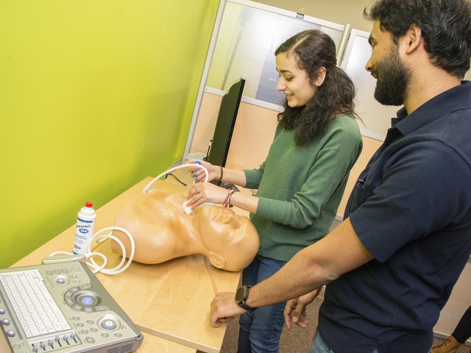 Rucha Bhide and Rohan Prabhu with dynamic haptic robotic trainer