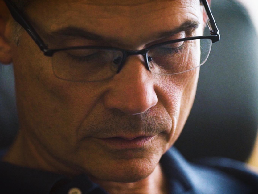 Man with glasses looking down