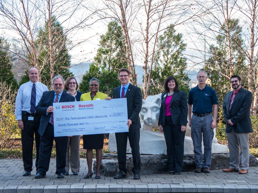 A group of people pose for check presentation ceremony