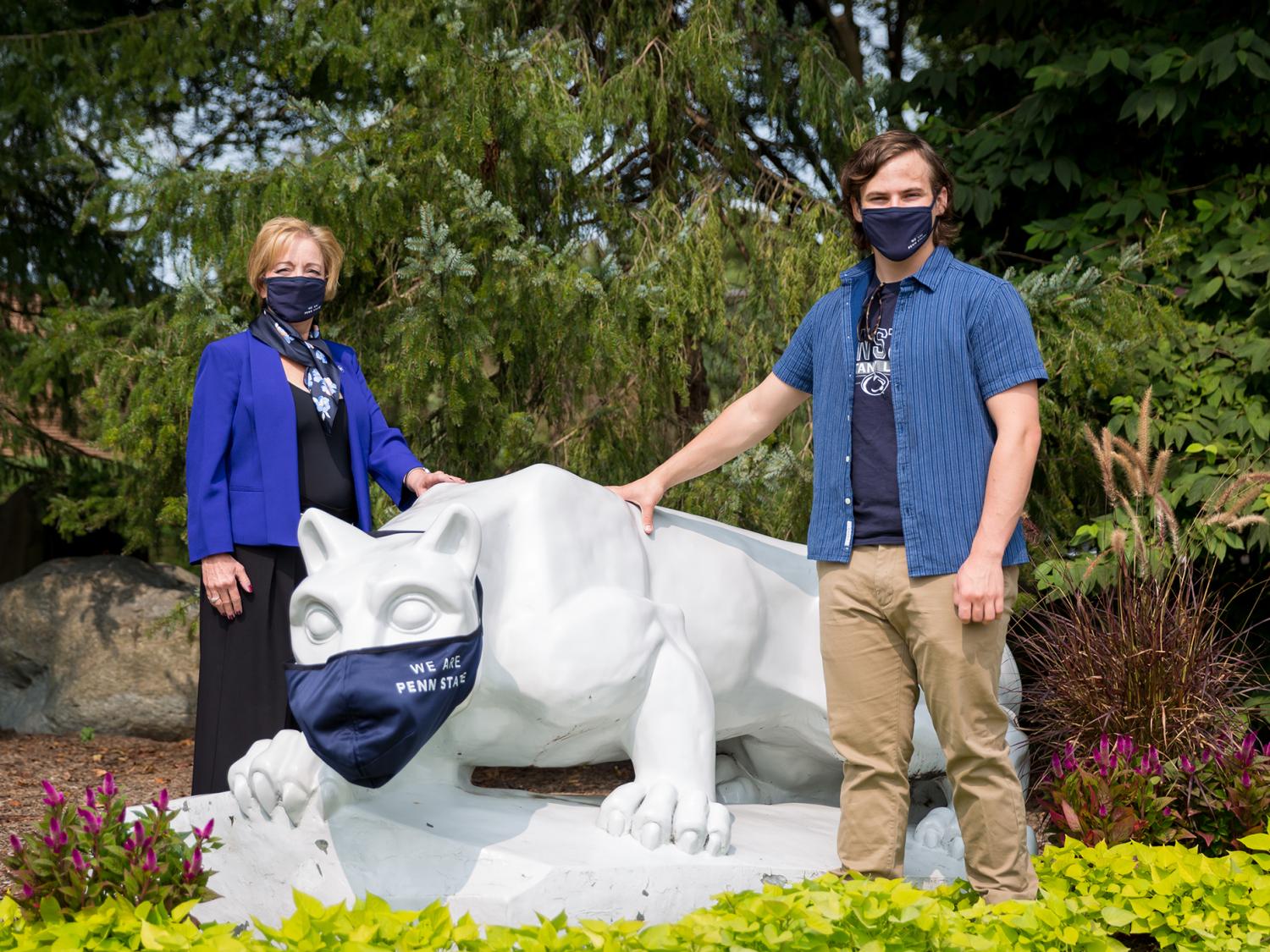 Two people stand by the Penn State Brandywine Nittany Lion shrine.