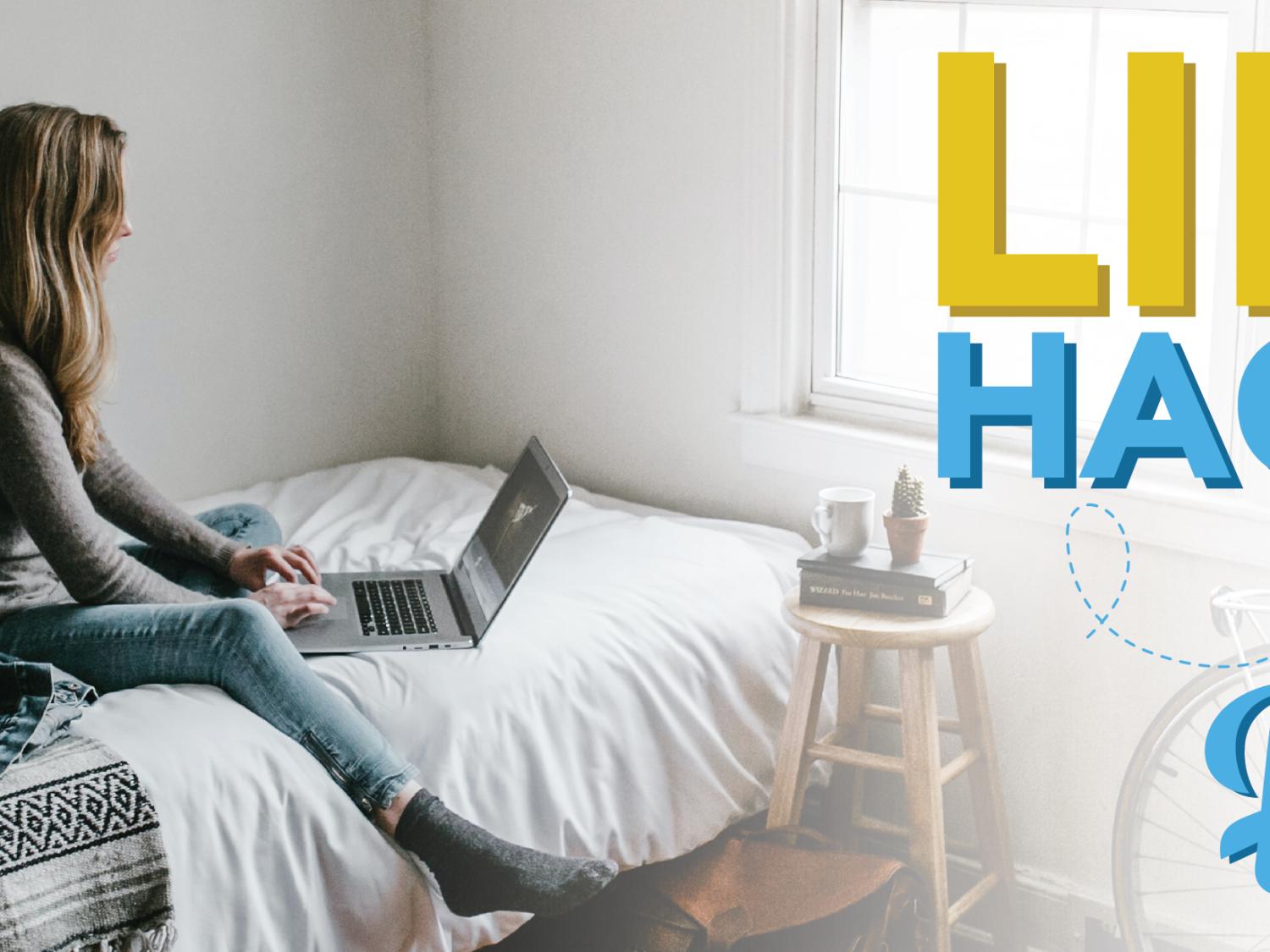 Woman sitting on her bed with a laptop
