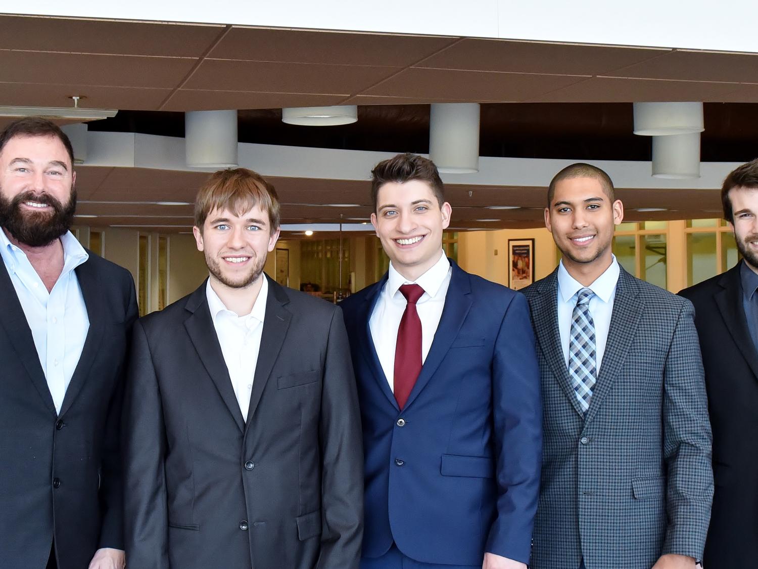 Four students pose with Greg Filbeck, director of the Black School of Business at Penn State Behrend