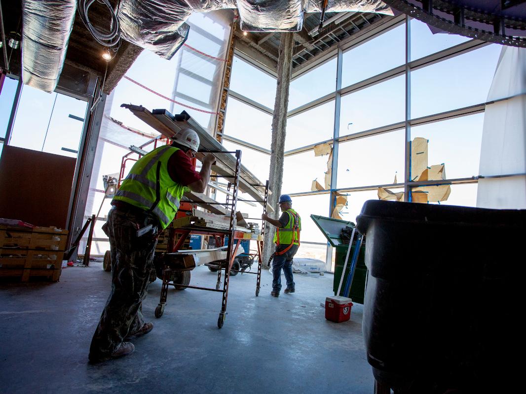 Construction workers work on the interior of a building