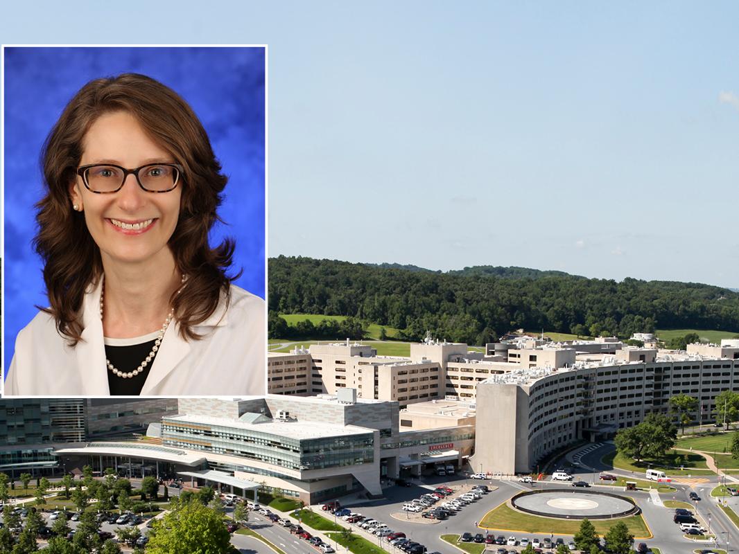 A head and shoulders professional portrait of Dr. Erika Saunders against a background image of Penn State Health Milton S. Hershey Medical Center and Penn State College of Medicine. 