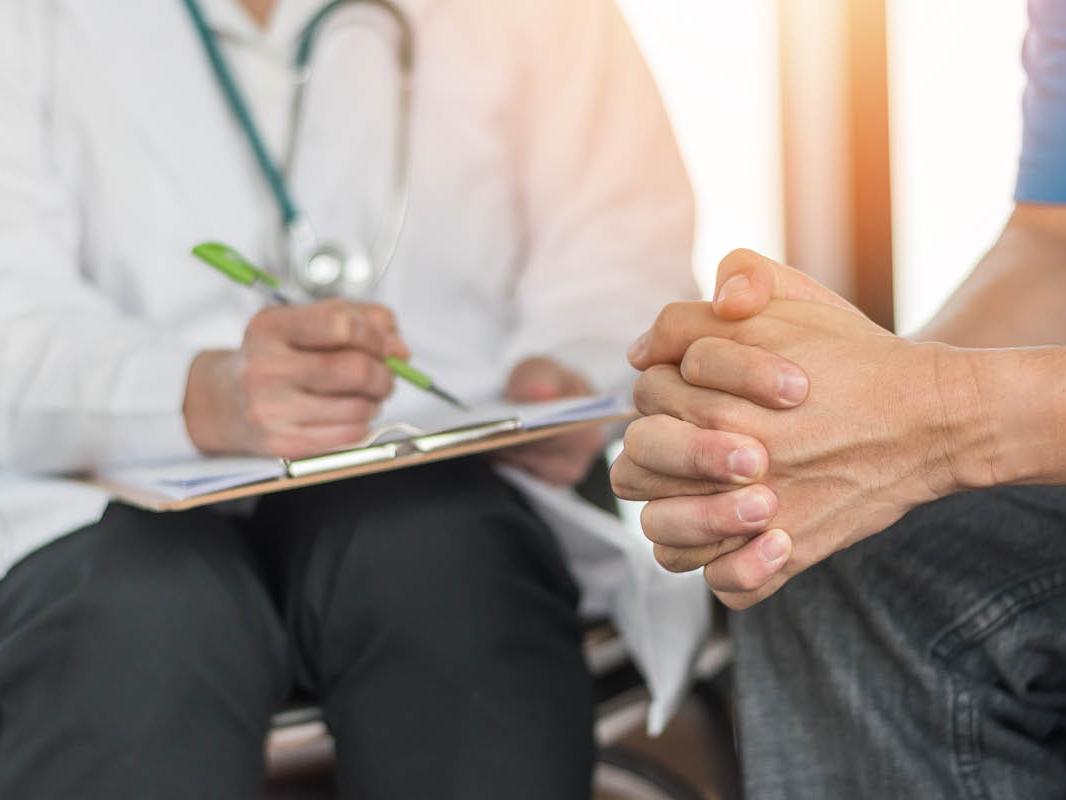 A doctor discusses a medical record with a cancer patient. 