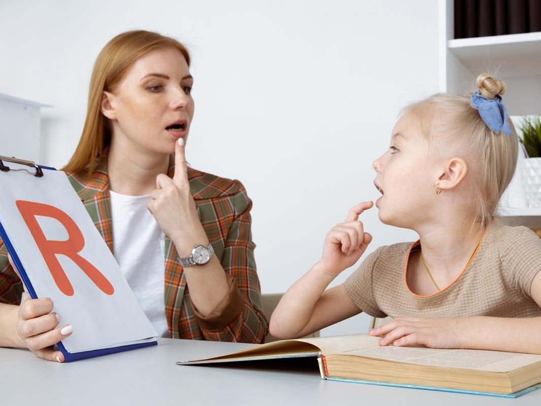speech therapy concept. patient kid with female therapist training pronunciation