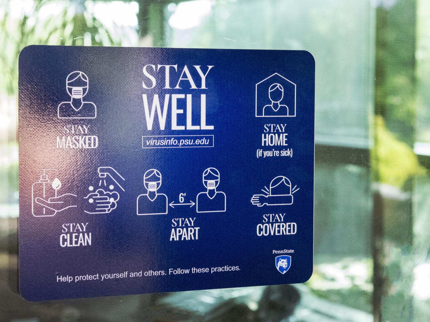 A blue "Stay Well" decal on a glass panel. 