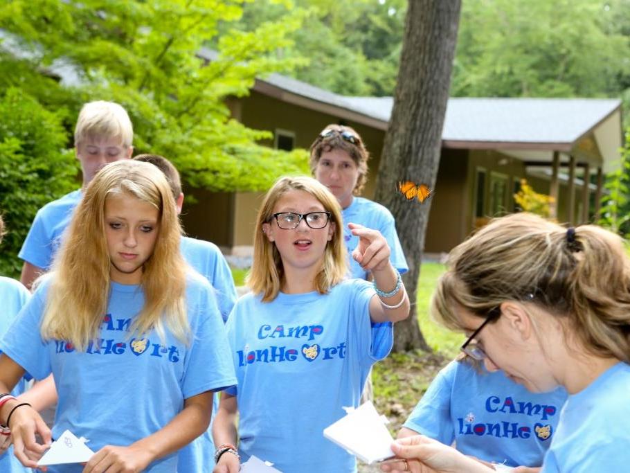 Campers at Camp Lionheart release butterflies into the air.