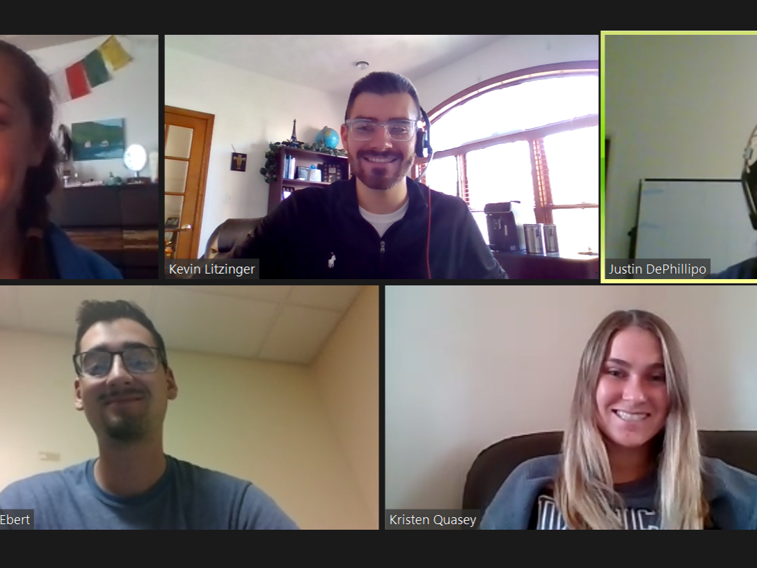 A group of students appear in a Zoom meeting smiling. 