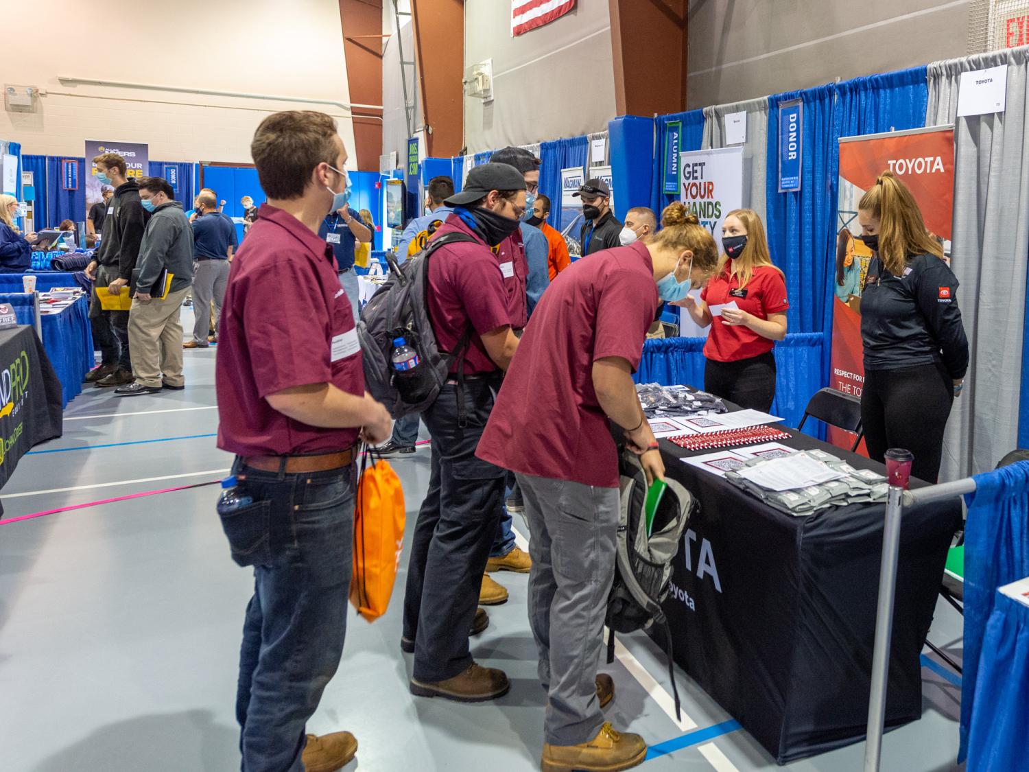 Students ask questions of a potential employer at a booth