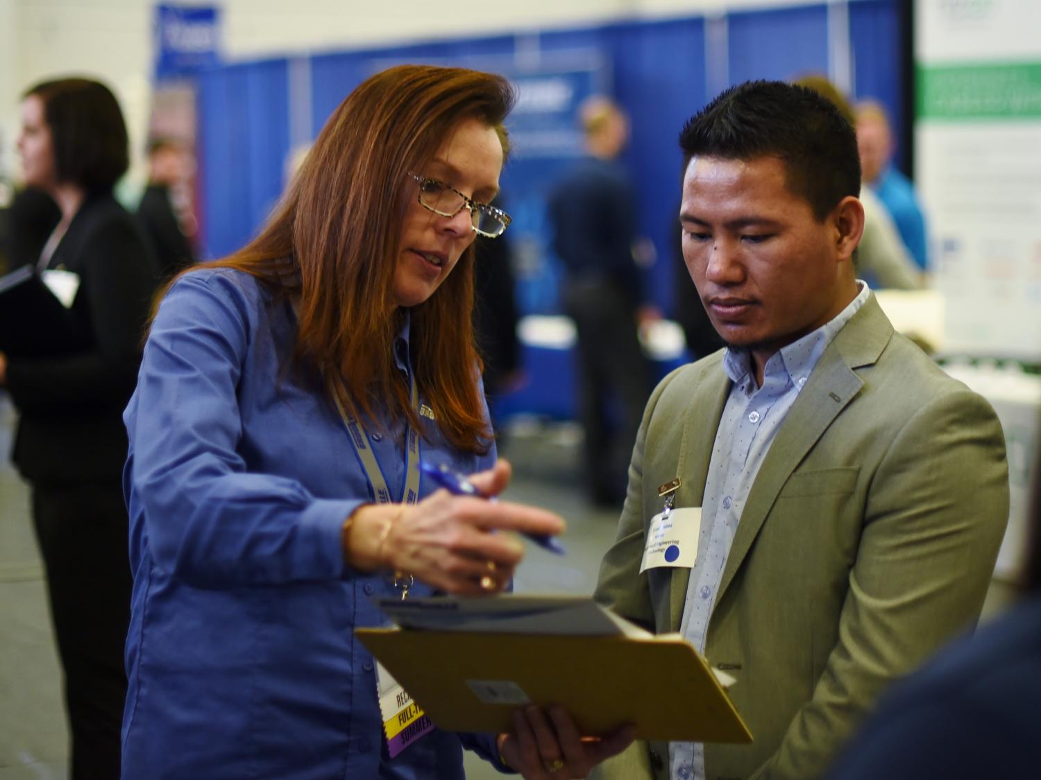Bikash Subba, a senior mechanical engineering technology major, converses with an employer at Penn State Behrend's spring Career and Internship Fair, held March 16 at the college.