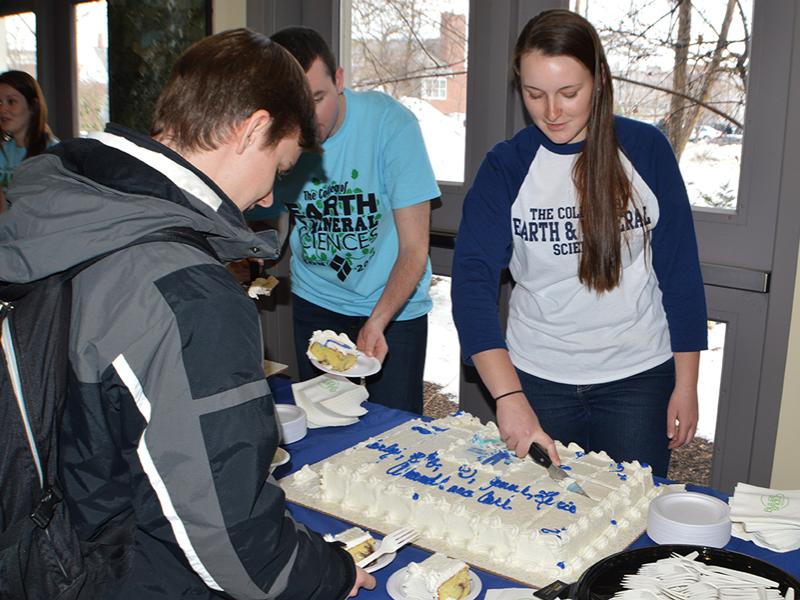 Carly Hinton cutting cake at a THON fundraiser