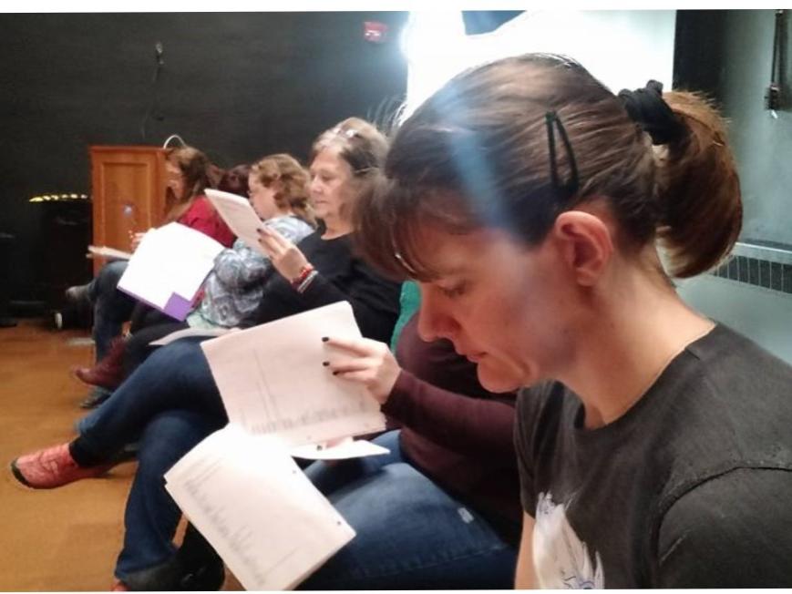 Several women study scripts for the upcoming drama production at Penn State Shenango