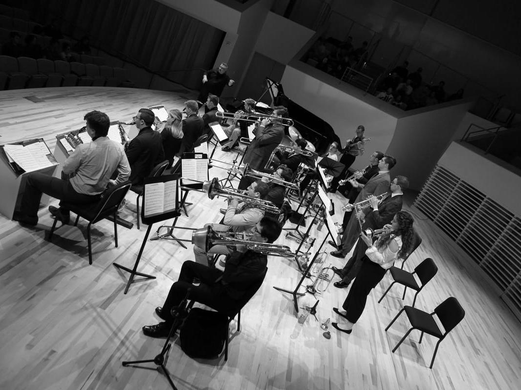 A group of people playing jazz instruments on a stage.