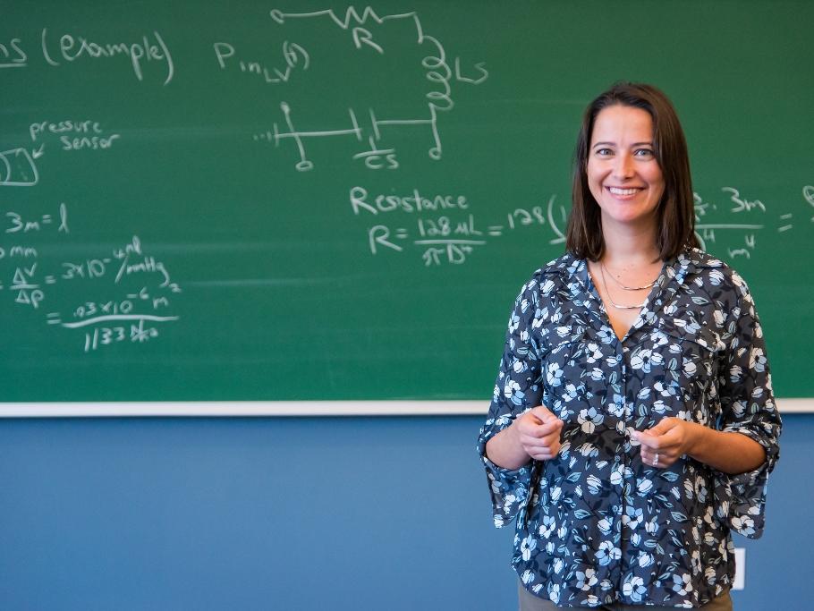A professor stands at a chalkboard.