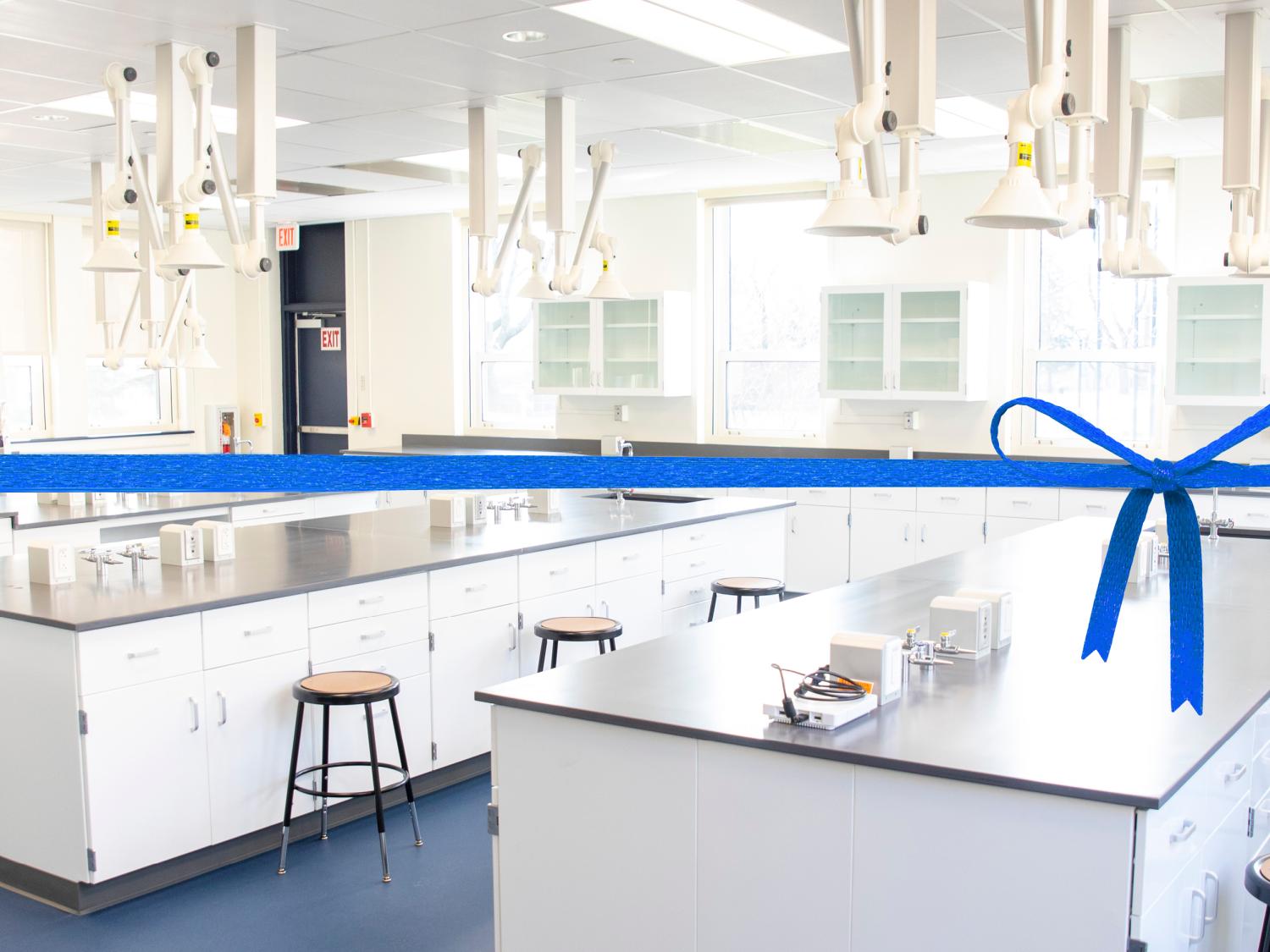 Photo of Penn State Schuylkill's new general chemistry lab, including snorkel ventilation system and lab desks, with a blue ribbon