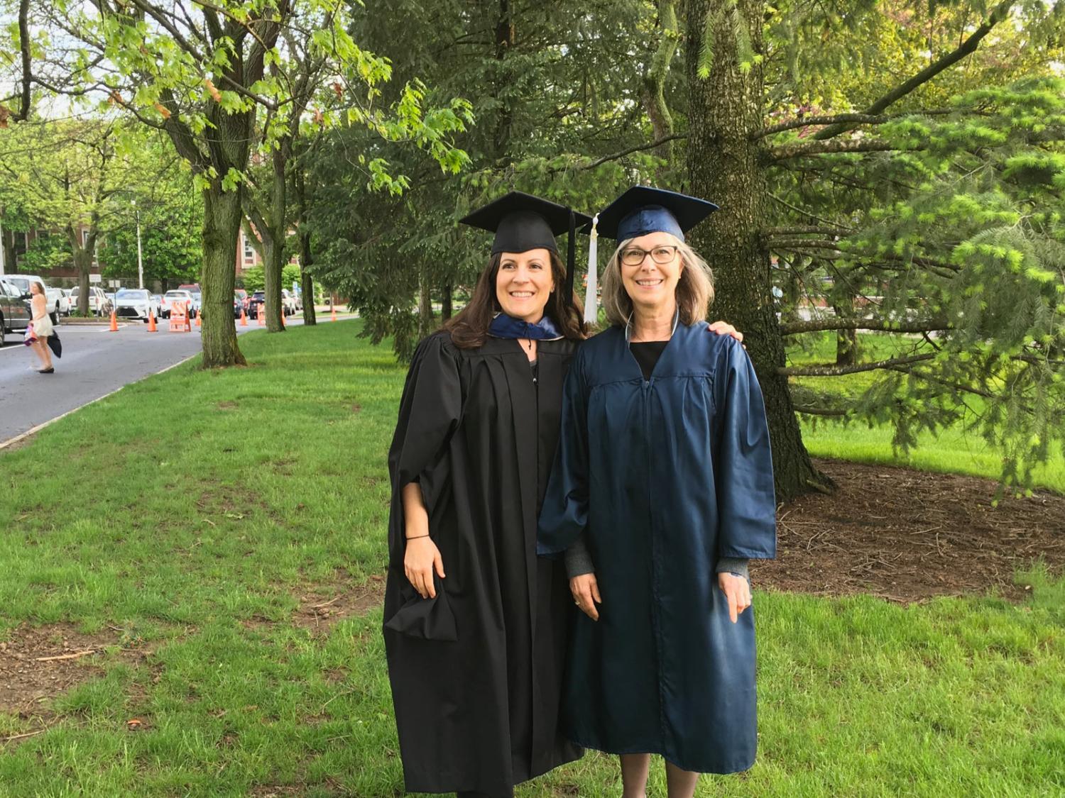 two women dressed in commencement robes