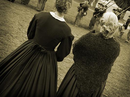 Civil war re-enactors look onto battlefield.