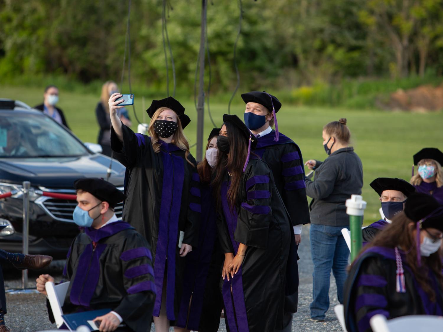 Penn State Dickinson Law graduates pose for a photo before taking their seats seats at the law school's commencement ceremony on Thursday, May 13, at Cumberland Drive-In in Newville, Pennsylvania